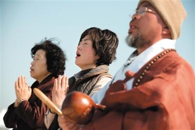 23日，一名僧侶引領(lǐng)人們?yōu)樗勒咂矶\。