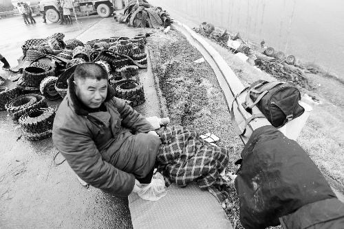 　出事司機(jī)的鞋找不到了，只好用塑料袋套著腳取暖