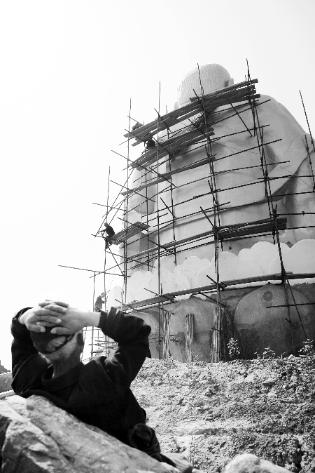 今年4月26日，工作人員將帆布蓋在“佛像”頭像上