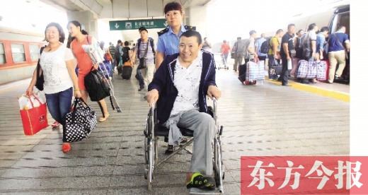 李剛手術后歸來，在車站工作人員幫助下走出鄭州火車站站臺  東方今報首席記者 張曉冬 攝