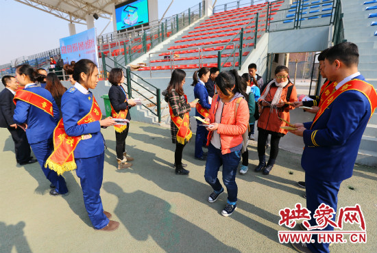 活動(dòng)現(xiàn)場工作人員給同學(xué)們發(fā)放宣傳冊(cè)、環(huán)保袋。