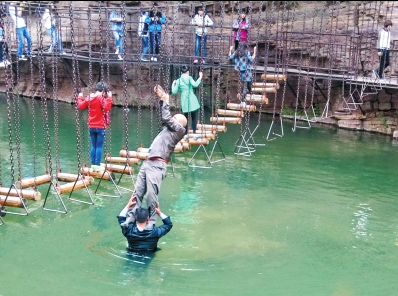 中年男游客正踩著景區(qū)安全員郭小明的肩膀過河。網友“@我的小名叫張孩”供圖