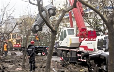 輸油管道爆炸后，搶修人員將被炸毀的車輛運(yùn)出現(xiàn)場(chǎng)。
