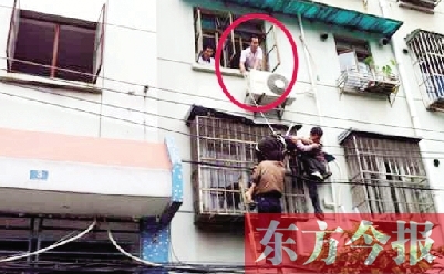 施救現(xiàn)場(chǎng)，劉鵬（圈內(nèi)）先用繩子捆住老太確保安全 勞動(dòng)報(bào)記者 郭娜 供圖