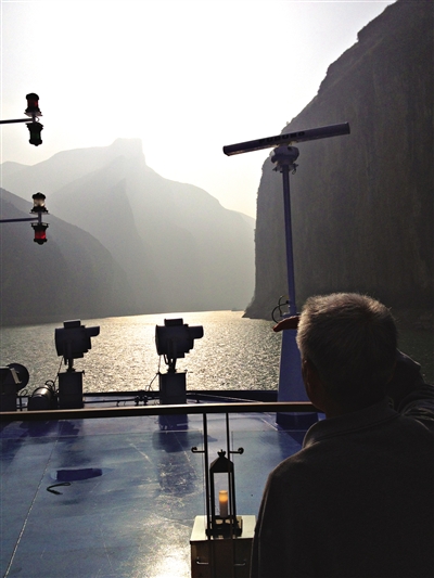 　　游客在游輪上遠(yuǎn)眺三峽風(fēng)光。