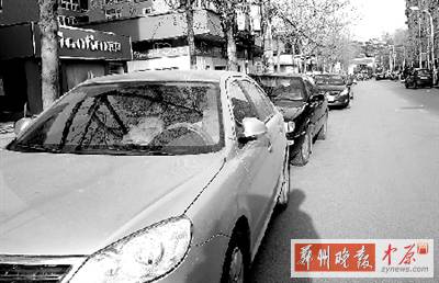 友愛(ài)路，路邊停了一排車，本來(lái)不寬的路就變得更窄了。