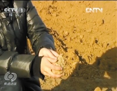 麻剛沙系麻剛石粉碎而成。記者找到一塊麻剛石，一捏就碎成粉末，硬度非常差。央視截圖