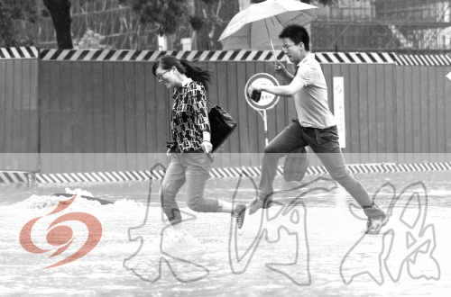 鄭州經(jīng)三路與北環(huán)交叉口處，積水較深，行人們不得不“練輕功”。 記者 白周峰 攝影