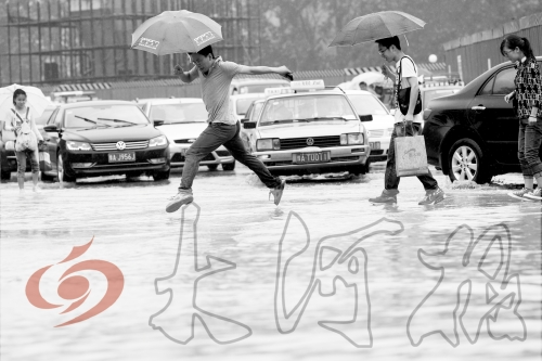 鄭州經(jīng)三路與北環(huán)交叉口處，積水較深，行人們不得不“練輕功”。 記者 白周峰 攝影