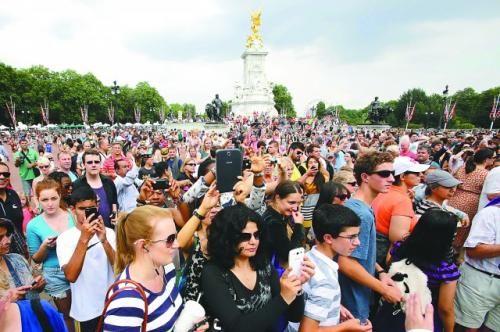 7月23日，在英國倫敦白金漢宮外，民眾們爭相閱讀“王室寶寶”出生的正式公告。