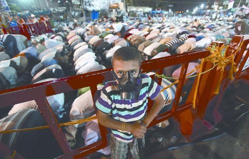 當?shù)貢r間28日晚，在埃及開羅納賽爾城，一名小男孩頭戴防毒面具參加穆兄會的集會示威。