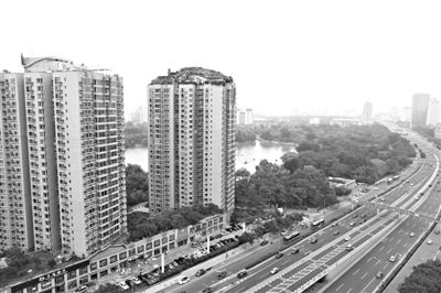 昨日，人濟(jì)山莊小區(qū)，與其他樓相比，B棟樓頂層天臺上違規(guī)建造了一棟兩層小樓，假山大樹俱全。新京報記者