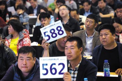 昨日，拍賣現(xiàn)場競拍者舉牌競拍。新京報記者