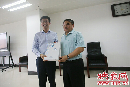 阿里云計(jì)算總裁胡曉明向河南省新聞出版廣電局局長(zhǎng)朱夏炎遞交《中原云平臺(tái)交付手冊(cè)》。