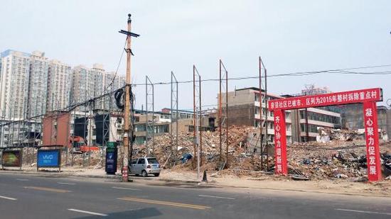 015年5月31日，在社區(qū)干部的帶頭拆遷下，親賢社區(qū)的“城中村改造”拉開(kāi)帷幕。由于前期“清產(chǎn)核資”及補(bǔ)償標(biāo)準(zhǔn)等因素，拆遷改造工作推進(jìn)并不順利。圖為位于體育西路東側(cè)集體所有的商鋪率先被拆遷完畢，用于遮擋的圍擋正在施工中。（拍攝：2015年9月16日）