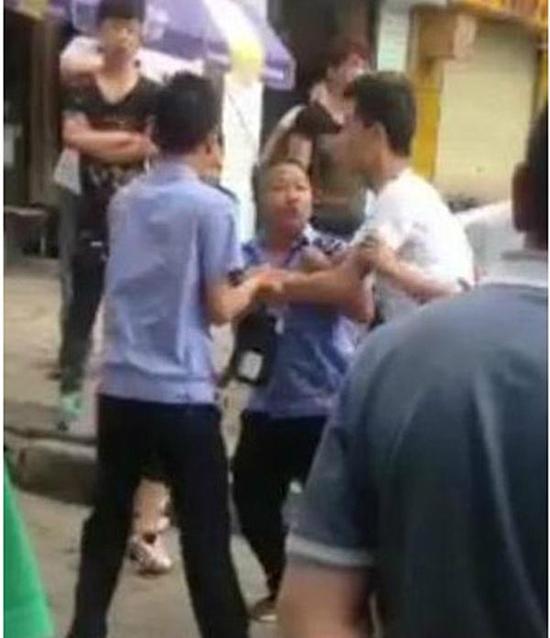 付某（右）與城管執(zhí)法人員廝打在一起。