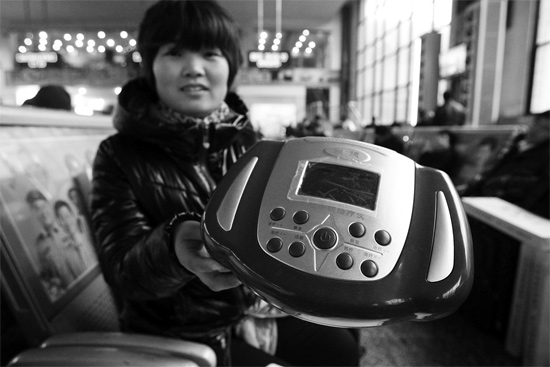 火車(chē)站候車(chē)室，李女士向記者展示她準(zhǔn)備孝敬父母的按摩儀
