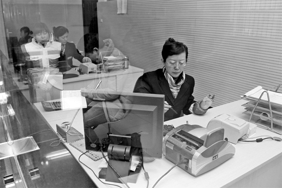 2月16日，鄭州市自來水總公司鄭東新區(qū)一營業(yè)廳，柜臺內工作人員正在為市民辦理業(yè)務