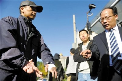 常林鋒在法院外展示雙手，他稱被燙傷的手因刑訊逼供且未得到及時救治