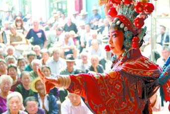 圖為8月15日戲曲演員在“流動(dòng)舞臺(tái)車”上表演傳統(tǒng)地方戲《穆桂英下山》。