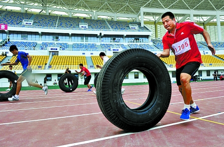 8月15日，運(yùn)動(dòng)員們正在進(jìn)行推輪胎賽跑。