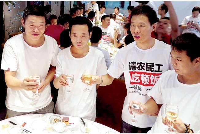 活動(dòng)發(fā)起人張楠（右二）給農(nóng)民工敬酒。