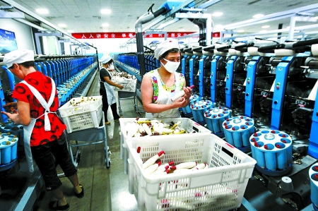 6月6日，舞鋼市鑫海紡織有限公司員工正在新建成的紡紗車間生產(chǎn)。