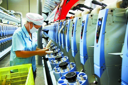 7月3日，在鄧州市永泰棉紡有限公司電腦控制全自動紡紗車間，紡織工人正在生產(chǎn)棉紗。