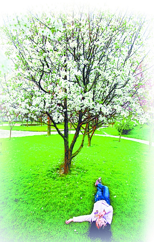 　孩子愜意地躺在社區(qū)內(nèi)的草坪上。