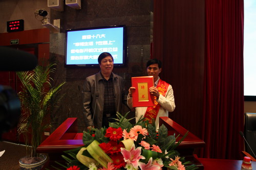 河南平頂山魯山縣電視臺的記者張朝岑，接過了河南電視臺9頻道總監(jiān)張克宣遞上的聘書。