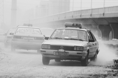 施工的道路上，車輛通過塵土飛揚。