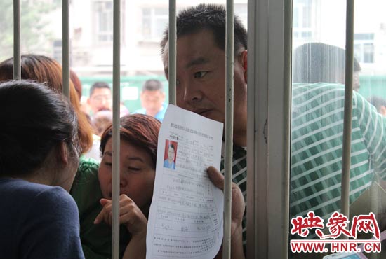 不少家長擠在報名窗口前咨詢報名事宜。