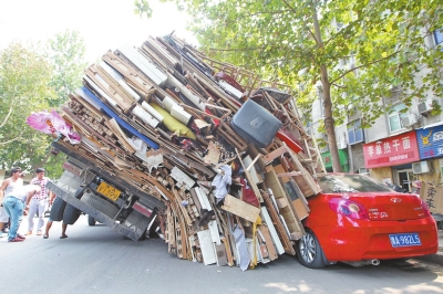 紅色小轎車被砸，卡在路邊動(dòng)彈不得。