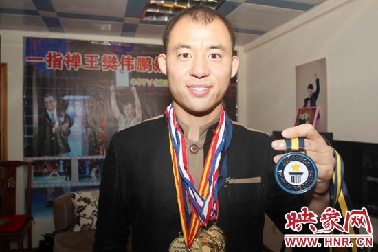 樊偉鵬向大家展示自己剛獲得的吉尼斯獎(jiǎng)牌。