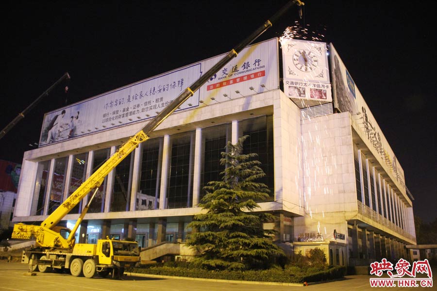 21點50分，切割機開始對中間最小的一塊牌進行切割。頂著“呼呼”的寒風，巨大廣告牌上火花四濺。