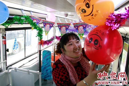 鄭州快速公交B3區(qū)間線車長李鵬云在車廂里懸掛氣球，布置圣誕車廂，營造歡樂圣誕氛圍