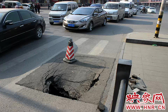 南陽路農(nóng)業(yè)路出現(xiàn)深坑，近看是因?yàn)闉r青充當(dāng)窨井蓋所致