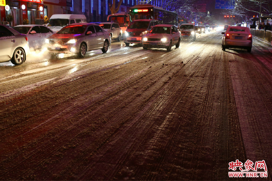 夜晚的雪路給出行的人們增加了困難。