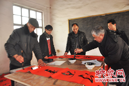 鞏義市魯莊鎮(zhèn)農(nóng)民書法愛好者正在寫春聯(lián)。