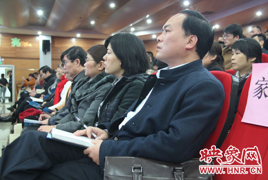 認(rèn)真聽取招生政策的學(xué)生家長。