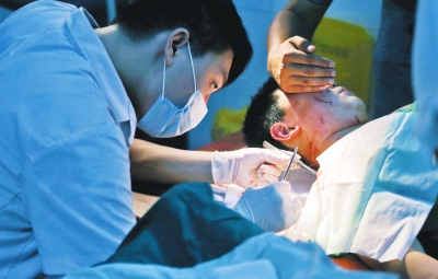 孩子身上有7道傷痕，其中兩道需要縫合，其他的均為擦傷，醫(yī)生正對他施治。