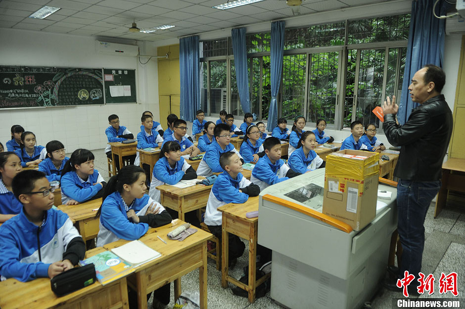 圖為老師正在向同學(xué)們講解用非智能手機(jī)對(duì)他們的好處。
