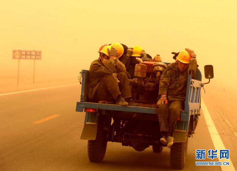 4月23日，一輛拉載公路施工人員的三輪車在沙塵暴中行駛在酒泉市瓜州縣城郊的公路上。