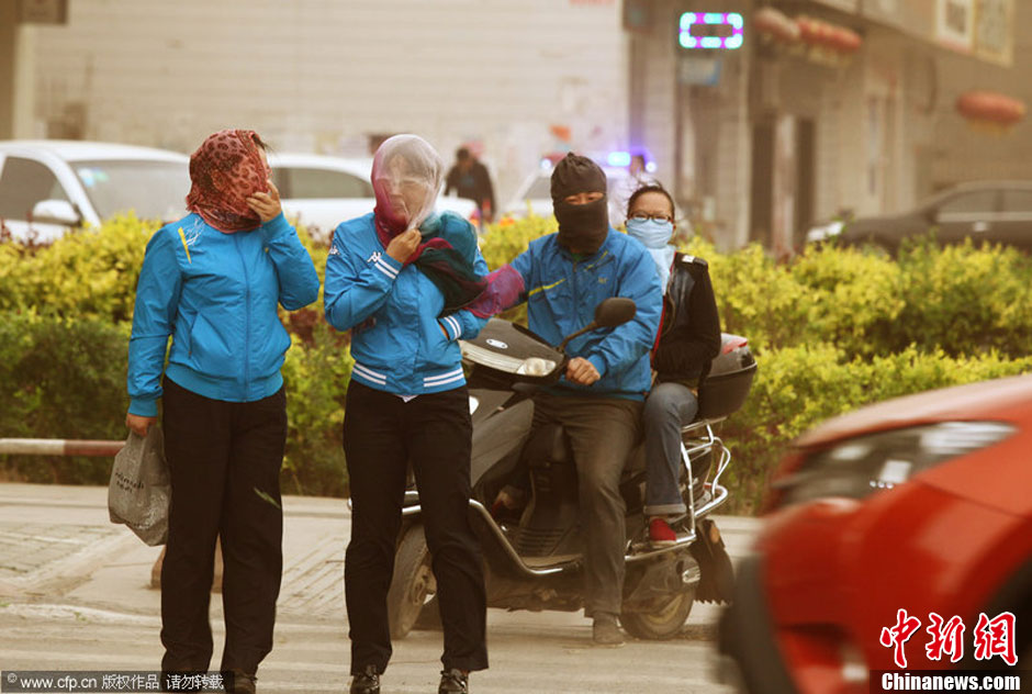 2014年04月23日，新疆維吾爾自治區(qū)吐魯番地區(qū)，市民戴著口罩行走在大風(fēng)沙塵中的吐魯番市街頭。