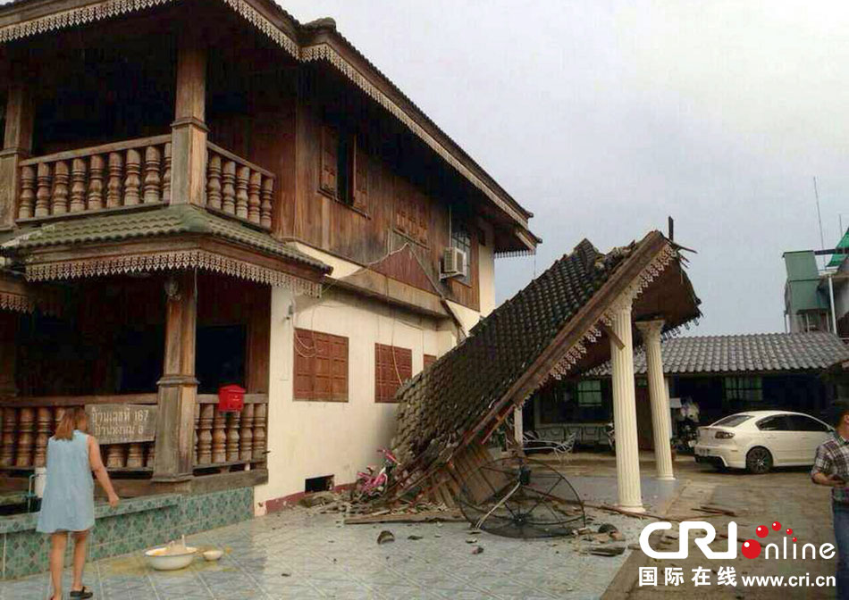 當?shù)貢r間2014年5月5日，泰國清萊，一名婦女看著受損的房屋。 圖片來源：東方IC