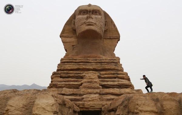 石家莊郊外，一名男子與山寨版獅身人面像合影留念。