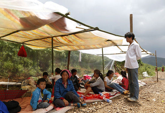 暴雨馬上來(lái)臨，村民們?cè)诤?jiǎn)易帳篷下躲雨。澎湃新聞 程藝輝 圖
