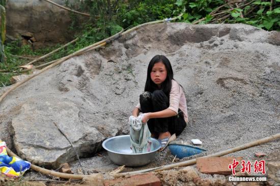 8月9日，云南巧家紅石巖村，10歲的劉鑫蕊在洗自己的衣服