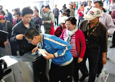 去年5月5日，14號線園博園站，乘客刷卡出地鐵。北京公交地鐵將實(shí)行計(jì)程票制，多乘坐多付費(fèi)。