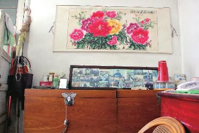 　陳會英將兒女的照片都裱起來，裝在一個大相框里，放在箱子上經(jīng)?？?，其中最多的就是劉金國的照片。